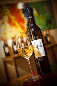 a bottle of wine sitting next to a wine glass at Boutique Hotel Toso Genussreich in Leutschach