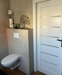a bathroom with a toilet and a tree on the wall at Dolna 64 in Strzegom +14 photos