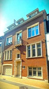 a large brick building with a balcony on a street at 't Kabinet in Blankenberge