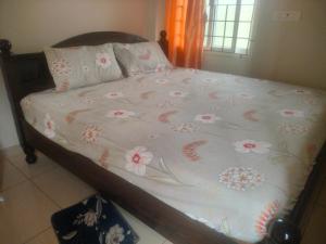 a bed with a blanket with flowers on it at Sri varahi rest house in Avanigadda