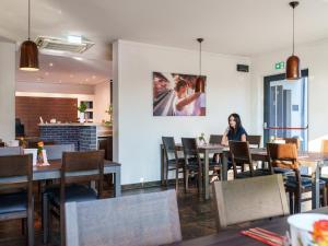 a woman sitting at a table in a restaurant at DuDa Boarding Apartments in Langenbruck