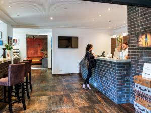 a woman standing at a bar in a restaurant at DuDa Boarding Apartments in Langenbruck