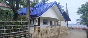 a house with a blue roof and a fence at Medecielo Villa in San Fernando