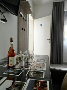 a bottle of wine sitting on a table with glasses at Apartman Centar in Sombor