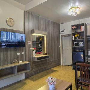 a living room with a tv on a wall at Victory Place in Bangkok