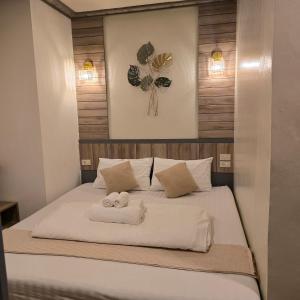 a bedroom with a bed with two towels on it at Victory Place in Bangkok