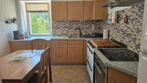 a kitchen with wooden cabinets and a table and a sink at Manötscherhof in Tires