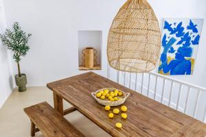 a wooden table with a bowl of fruit on it at Maison Mariel in Skopelos Town