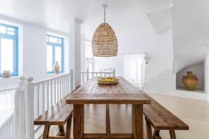 a dining room with a wooden table and a bowl of fruit at Maison Mariel in Skopelos Town