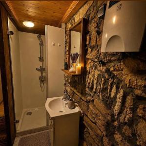 a stone bathroom with a sink and a shower at Old mill in Štore