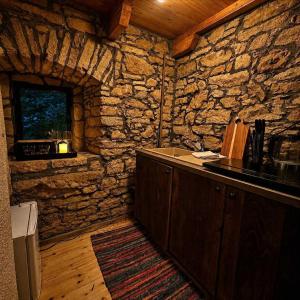 a kitchen with a counter and a stone wall at Old mill in Štore +13 photos