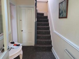 a hallway with a staircase with a white door at Bayview in Ballysadare
