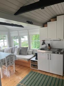 a kitchen and living room with a couch and a table at Pikkumökki Sveastugan in Rövik