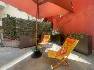 a patio with two chairs and a table with an umbrella at Priamar house in Savona
