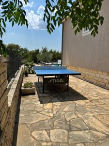 a ping pong table sitting on a stone patio at Villa Vuletic in Kula Atlagić