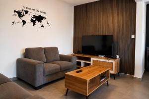 a living room with a couch and a flat screen tv at La Terrace Brocus in Bouchon