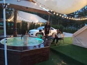 a group of people in a hot tub under an umbrella at Riverside Glamping Resort Kanchanaburi in Kanchanaburi City