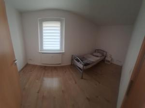 an empty room with a bed and a window at Monteurswohnung1 in Halle an der Saale