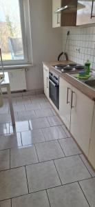 a kitchen with a tiled floor with a stove top oven at Monteurswohnung1 in Halle an der Saale