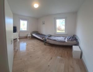 a bedroom with two beds and a wooden floor at Monteurswohnung1 in Halle an der Saale