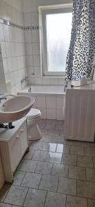a bathroom with a sink and a toilet and a bath tub at Monteurswohnung1 in Halle an der Saale