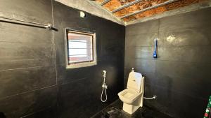 a bathroom with a toilet and a window at AV Meadows in Kanchipuram +100 photos