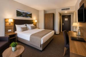 a hotel room with a large bed and a living room at Hotel M K in Nuremberg