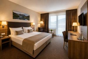 a hotel room with a large bed and a television at Hotel M K in Nuremberg