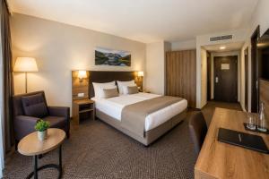 a hotel room with a large bed and a desk at Hotel M K in Nuremberg