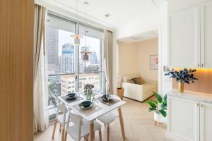 a living room with a white table and a large window at Skyline Suites Sukhumvit 11 in Bangkok