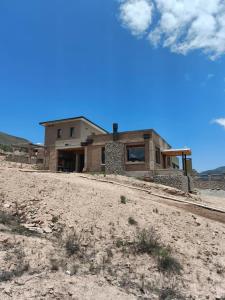 a house in the middle of a dirt field at CasaVid - Private Boutique Chalet & Spa - Vistas 360 in Tafí del Valle