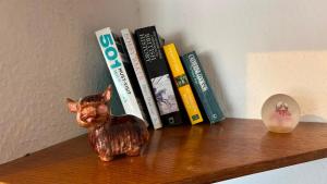 a cat figurine sitting on a shelf with books at The Paddocks in Bicton
