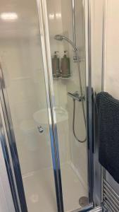 a shower with a glass door in a bathroom at The Paddocks in Bicton