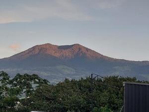a mountain in the distance with trees in the foreground at Hospedaje del norte in Quesada