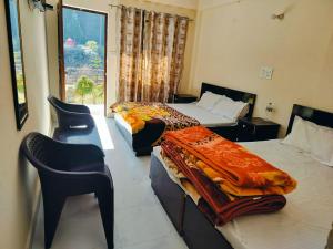 a hotel room with two beds and a window at Uttarkashi Resort in Uttarkāshi
