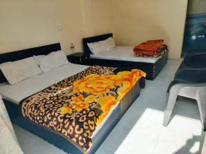 a bedroom with two beds with flowers on them at Uttarkashi Resort in Uttarkāshi +4 photos