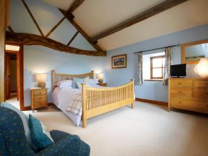 a bedroom with a bed and a tv and a couch at Rowan Cottage - Uk4187 in Hazlehead Bridge