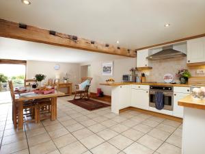 a kitchen with white cabinets and a table and a dining room at Rowan Cottage - Uk4187 in Hazlehead Bridge