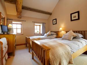 a bedroom with two beds and a flat screen tv at Rowan Cottage - Uk4187 in Hazlehead Bridge