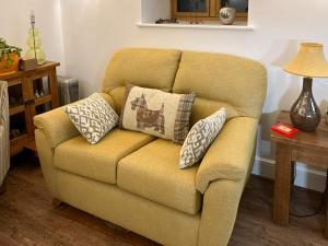 a couch with pillows on it in a living room at Maggie's Place in Holsworthy