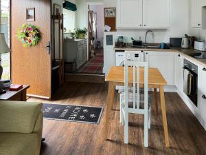 a kitchen with a table and chairs in a room at Maggie's Place in Holsworthy