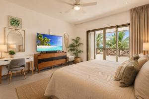 a bedroom with a bed and a desk and a television at Casa Seven Ocean Front with Private C hef Included in Isla Mujeres