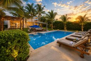 a swimming pool with lounge chairs and a house at Casa Seven Ocean Front with Private C hef Included in Isla Mujeres