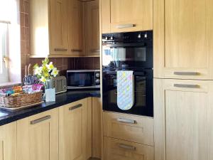 a kitchen with a refrigerator with a tie on it at California Halt in Scratby