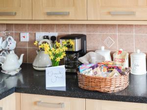 a kitchen counter with a basket of food and flowers at California Halt in Scratby