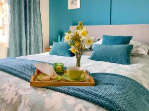 a tray with a vase of flowers on a bed at California Halt in Scratby +7 photos