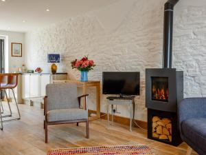 a living room with a fireplace and a tv at Wrens Perch in Brixham