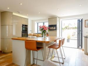 a kitchen with a counter with a vase of flowers at Wrens Perch in Brixham