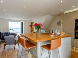 a kitchen with a table with a vase of flowers on it at Wrens Perch in Brixham