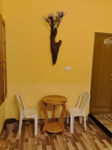 a table with two chairs and a tree on the wall at Clintons Cove in Cochin